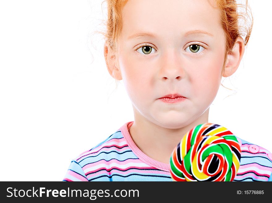 Portrait of a little red-haired girl licking lollipop. Isolated over white background. Portrait of a little red-haired girl licking lollipop. Isolated over white background.