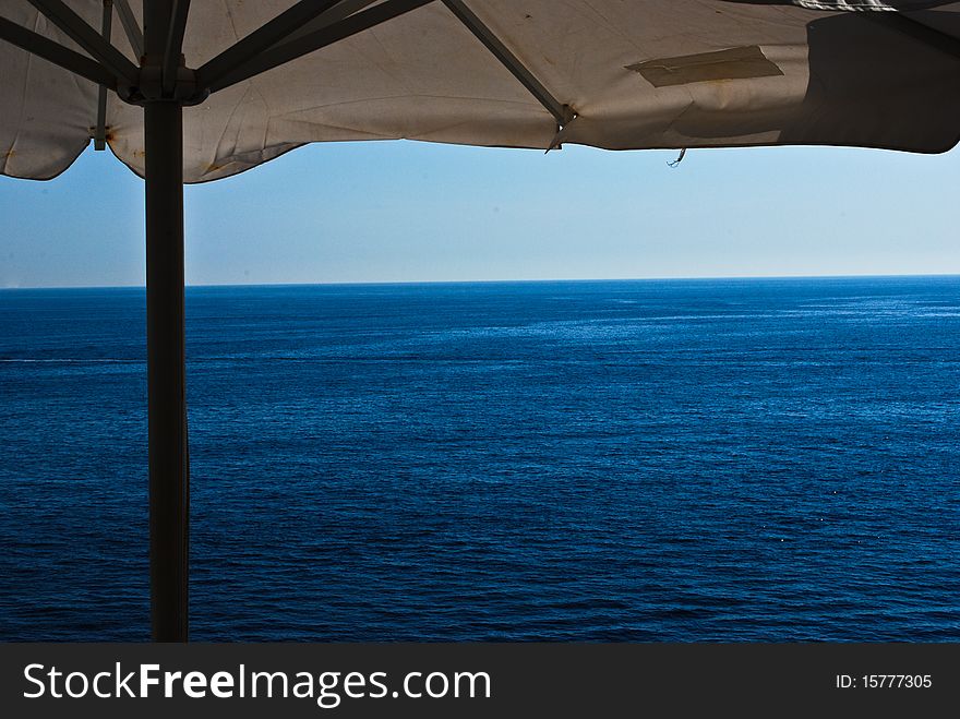 Blue sea under a beach umbrella