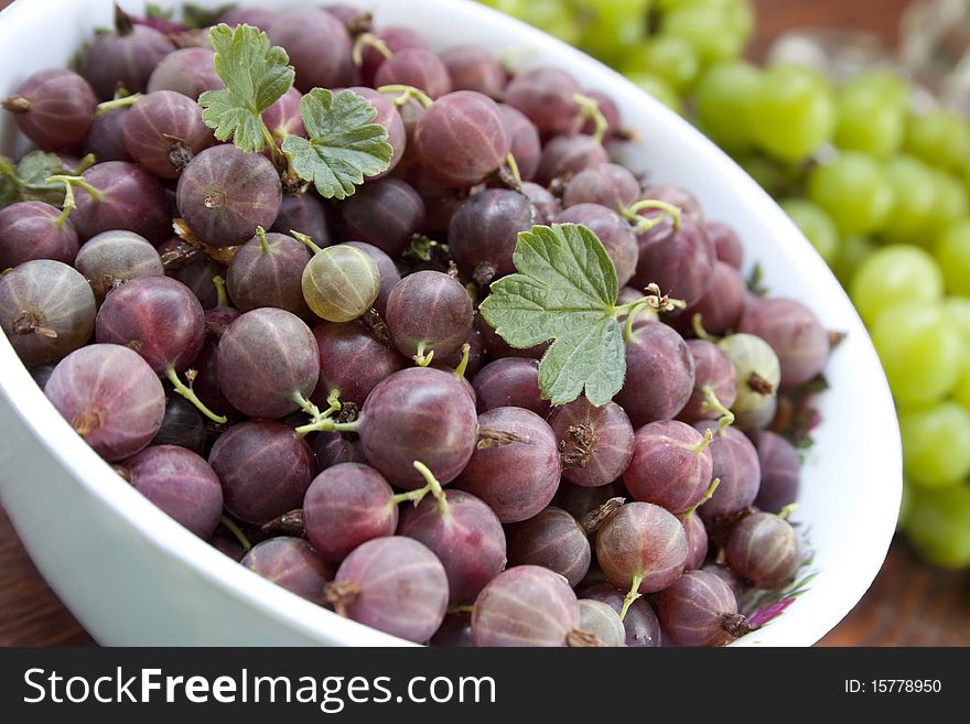 Red gooseberries in a white cup closeup