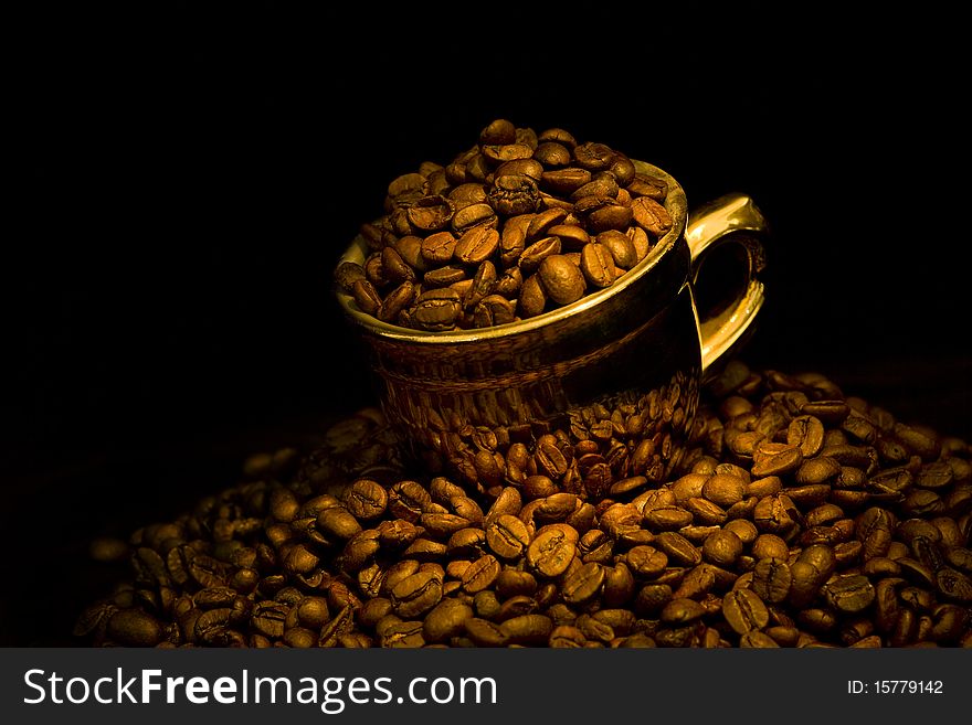 Gold cup with coffee beans. Gold cup with coffee beans