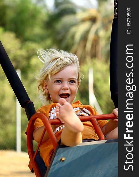 Cute little boy on a swing at the playground.