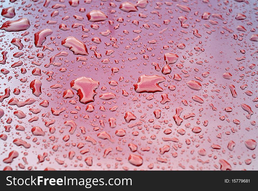 Abstract red toned photo of water drops on a clean car surface. Abstract red toned photo of water drops on a clean car surface.