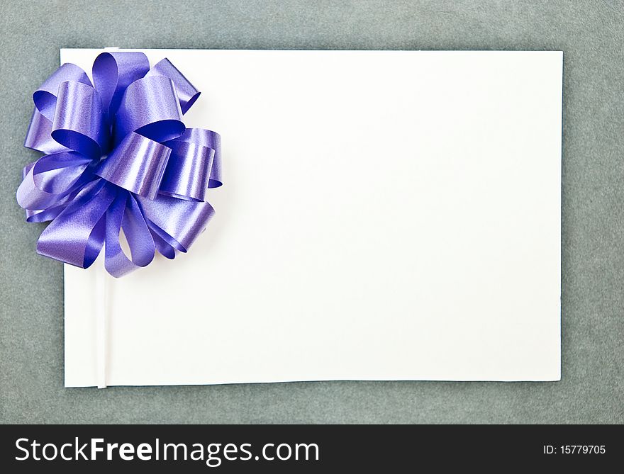 White paper blank with bow on grey background. White paper blank with bow on grey background