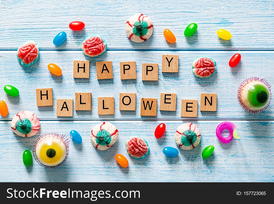 Halloween background - cady and sweets on blue wood background