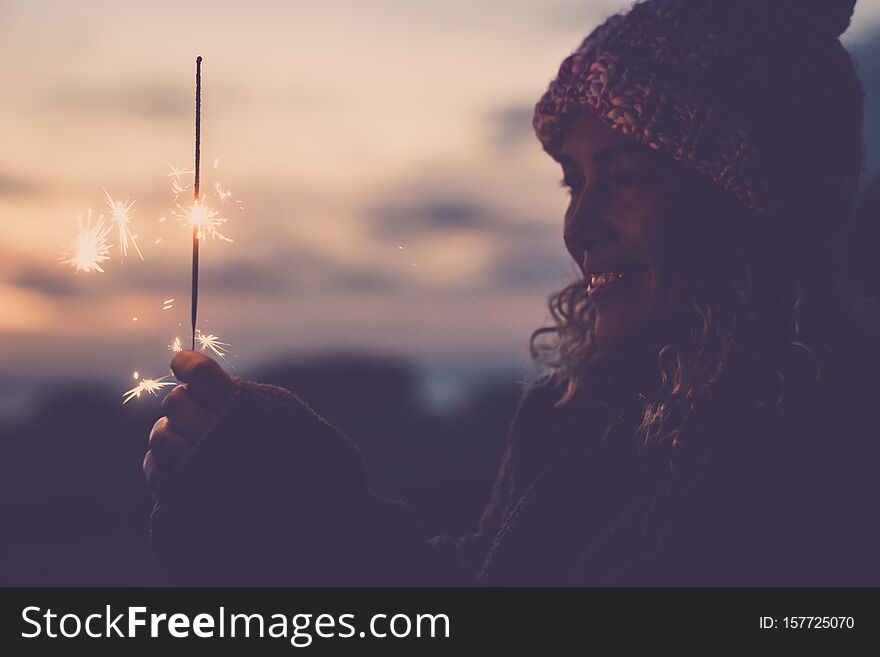 Cheerful Caucasian Woman With Winter Hat Celebrate Outdoor With Fire Sparkler - New Year Eve And Event- Happiness For Alternative