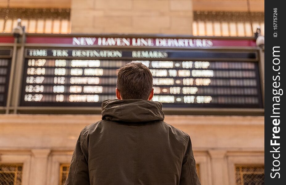 Man checking the train timetable in the grand central terminal in new york