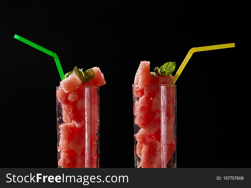 Photo of two glasses with abstract watermelon delicious cocktail on black background. Photo of two glasses with abstract watermelon delicious cocktail on black background