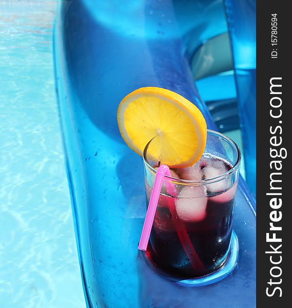 Refreshing summer drink in an inflatable chair relaxing in the pool