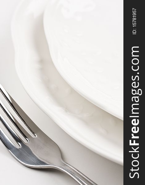 Close up of white dinner plates with silver knife and fork. Close up of white dinner plates with silver knife and fork.