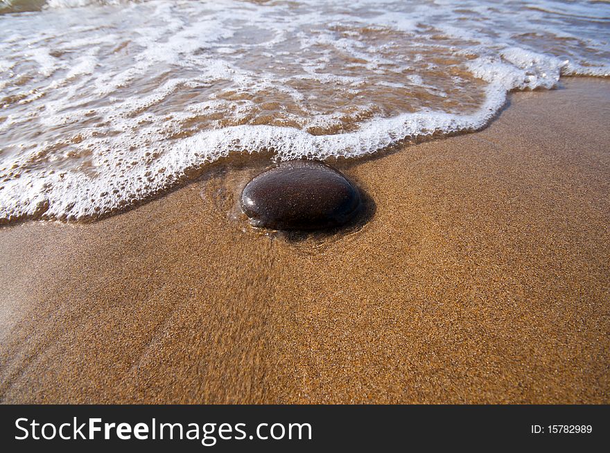 Seashore with waves and foam and blue sky