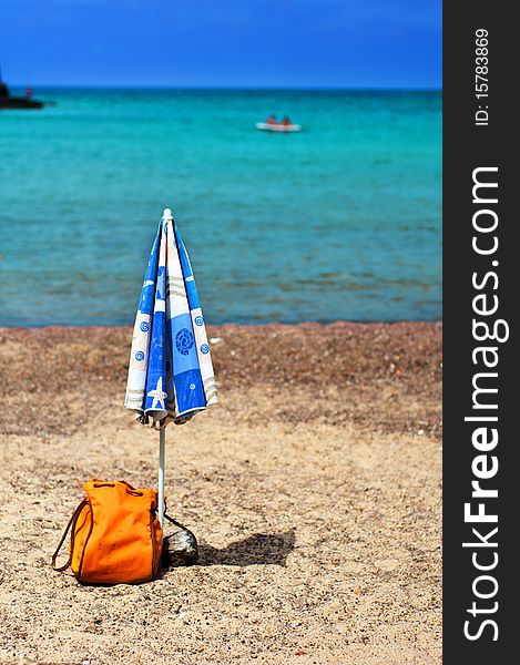 Umbrellas and beach bag on the coast of Sardinia