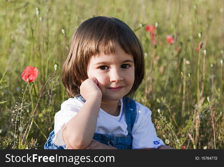 Portrait of a little girl in poppies field