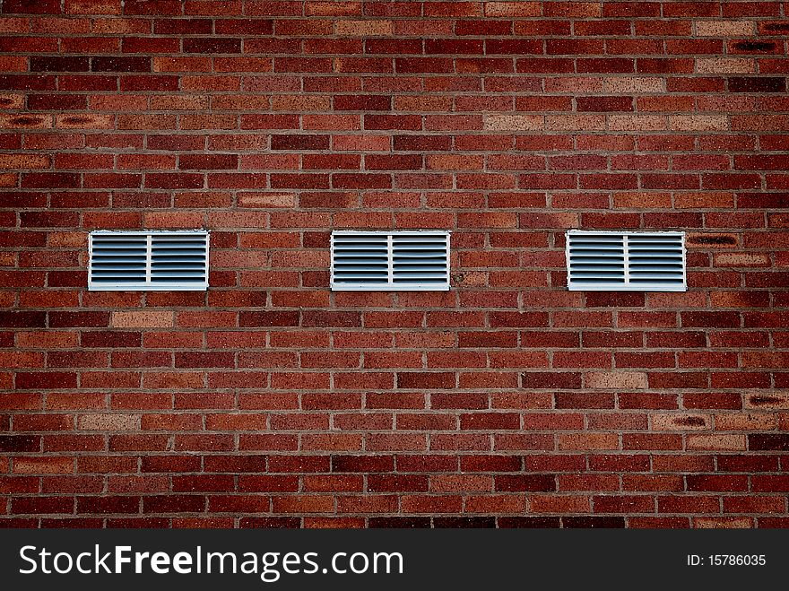 Detail shot of an old brick wall with metal vents. Detail shot of an old brick wall with metal vents