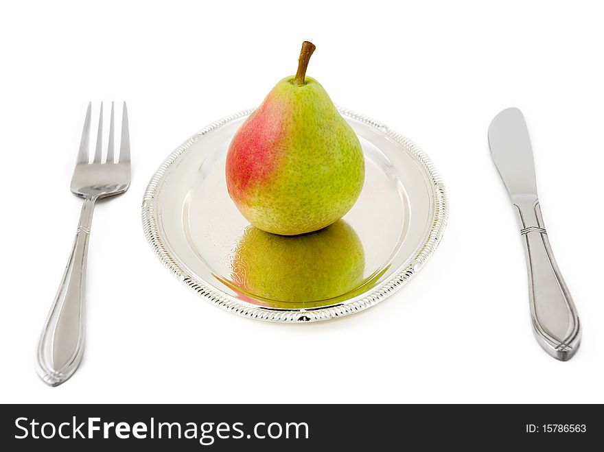 Pear on a silver plate are photographed on the white background