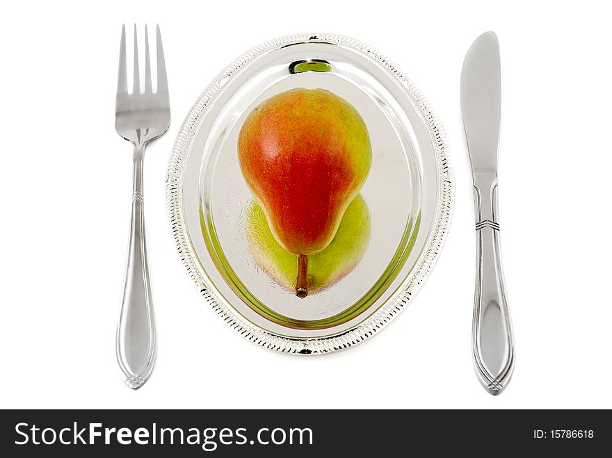 Pear on a silver plate are photographed on the white background
