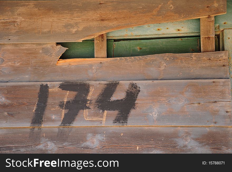 Painted gate number on wooden wall