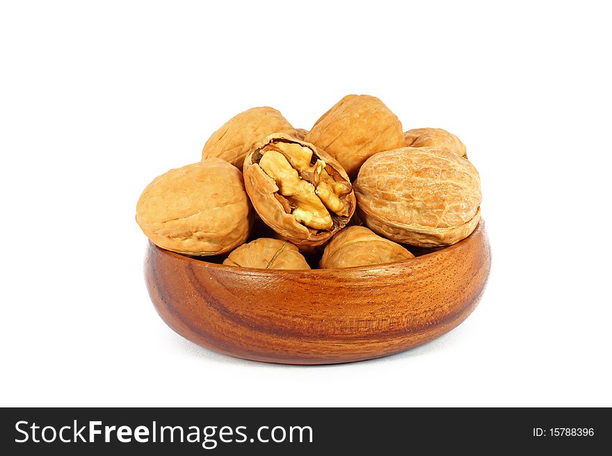 Walnuts in wooden bowl isolated on white