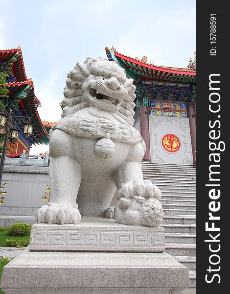 Lion statue from granite rock and temple in chinese style.