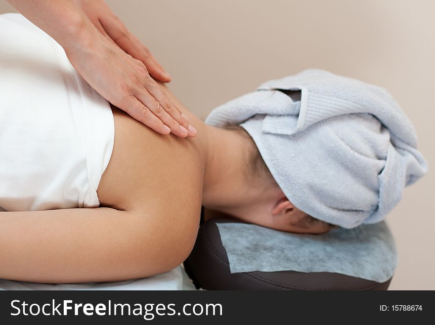 Young woman in a spa salon lays on a table and receives a facial massage