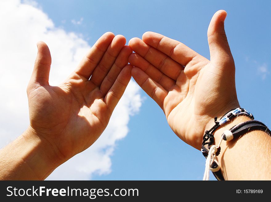 A pair of hands on the background of sky.