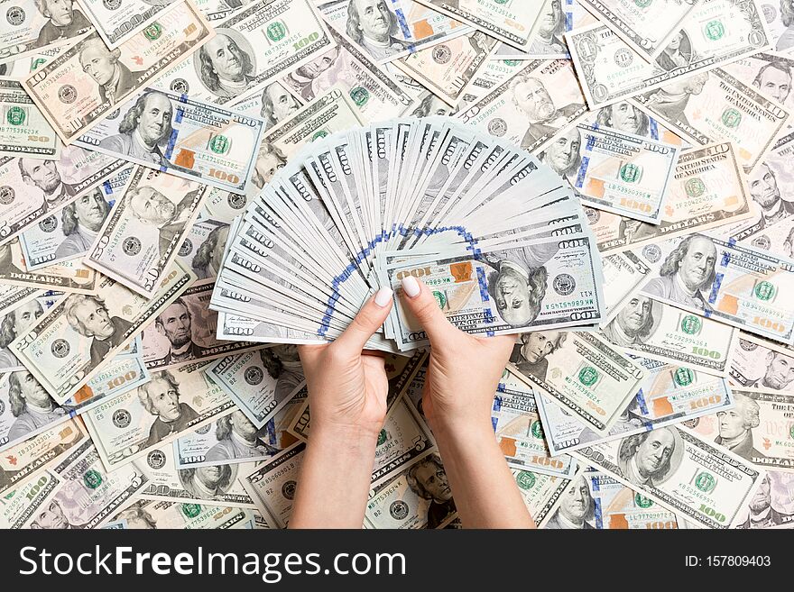 Top view of female hands counting money on different dollar background. Debt concept. Investment concept.