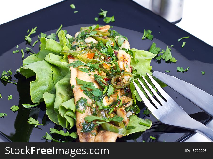 Oven cooked fish on a black plate