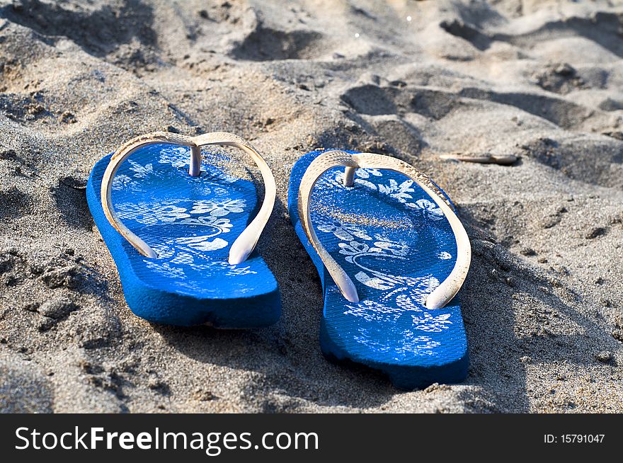 Slippers in the sand sea summer. Slippers in the sand sea summer