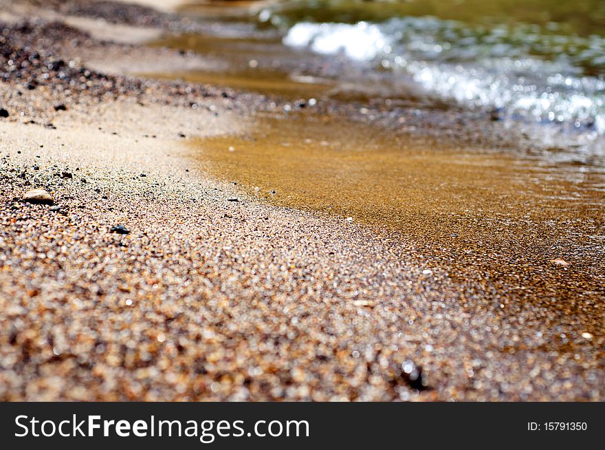 Seashore with waves and foam and blue sky