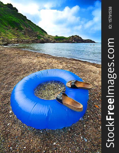 Buoy blue sea on the beach with flip flops. Buoy blue sea on the beach with flip flops