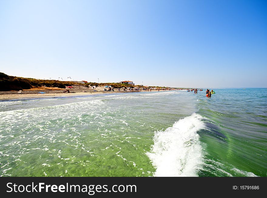 Seashore with waves and foam and blue sky