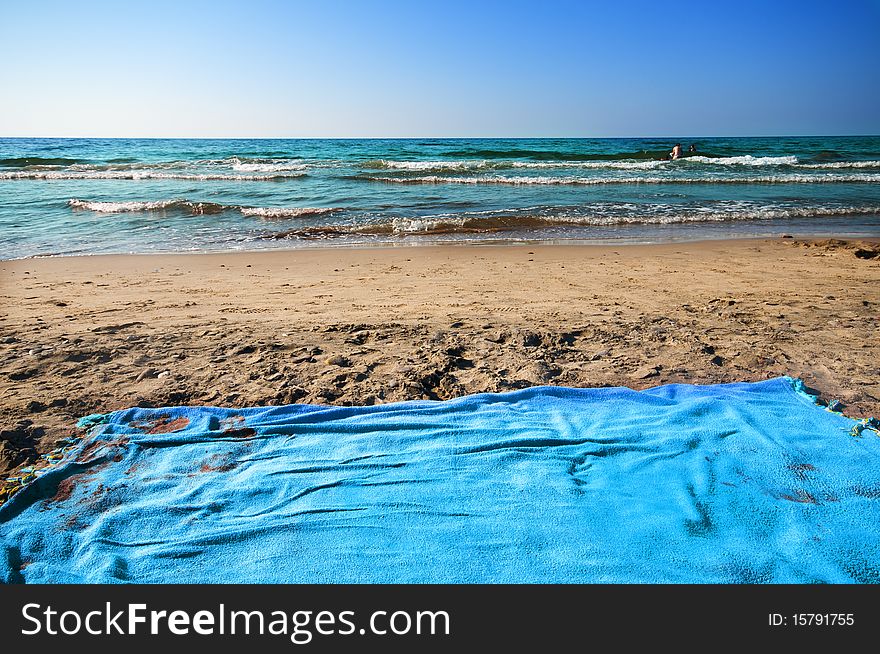 Beach towel and sea on the coast of Sardinia