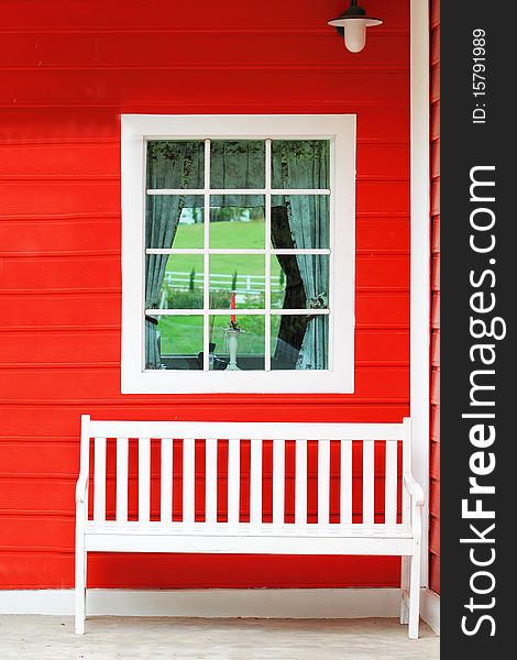 White chair against white window and red wall