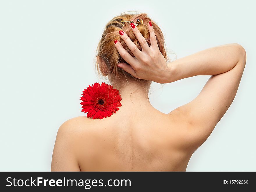 Figure of the young girl from a back with a red flower. Figure of the young girl from a back with a red flower