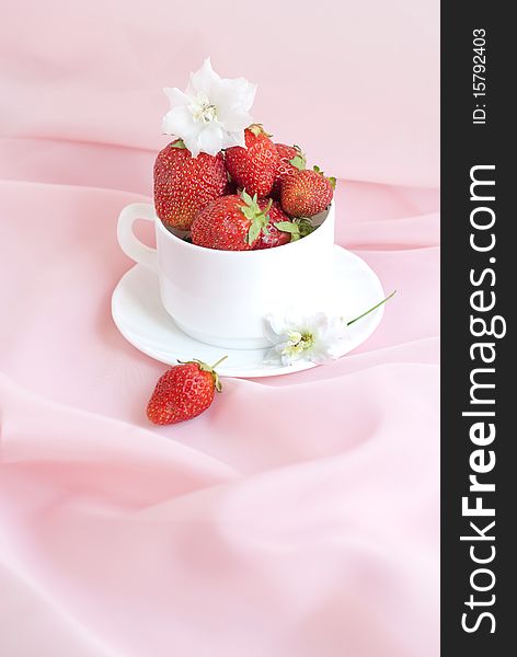Full cup ripe strawberry on a pink background