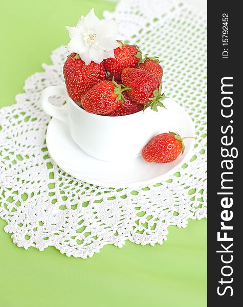 Cupful of ripe strawberries lace in green background