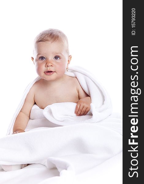 Beautiful baby under a white towel on white background