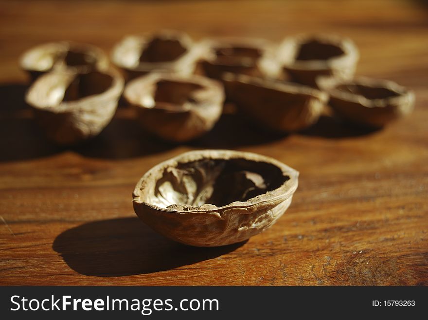 A series of  walnuts shells arranged on a table. A series of  walnuts shells arranged on a table
