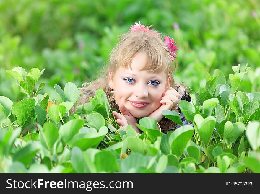 Beautiful woman in grass with gerbera flowers