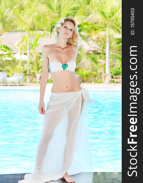 Young woman posing on the edge of swimming pool. Young woman posing on the edge of swimming pool