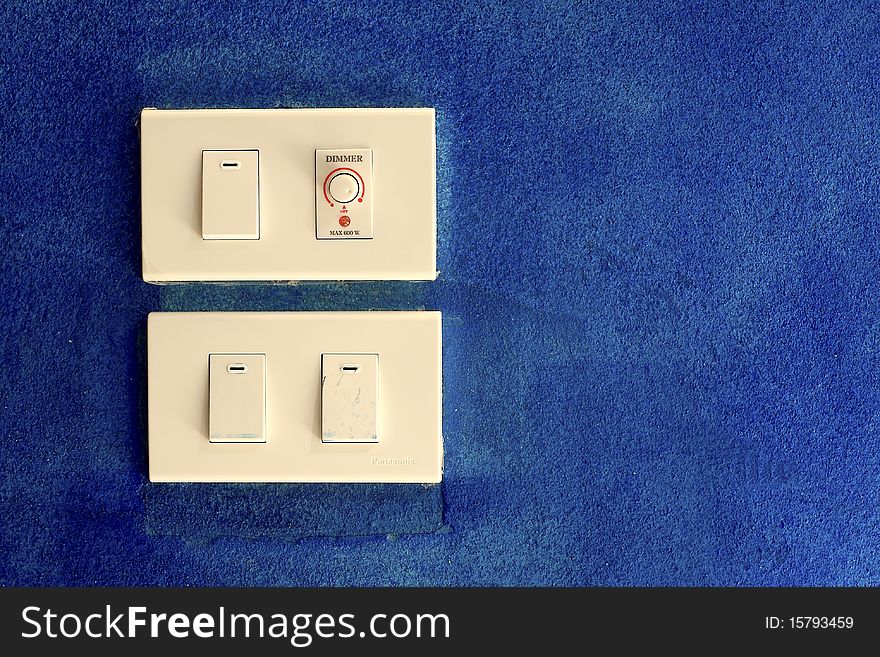 Old light switch on blue wall