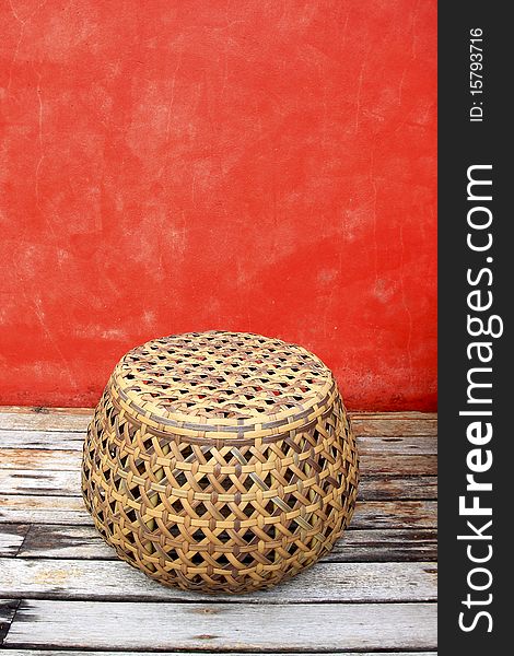 Rattan chairs with red walls on old wood