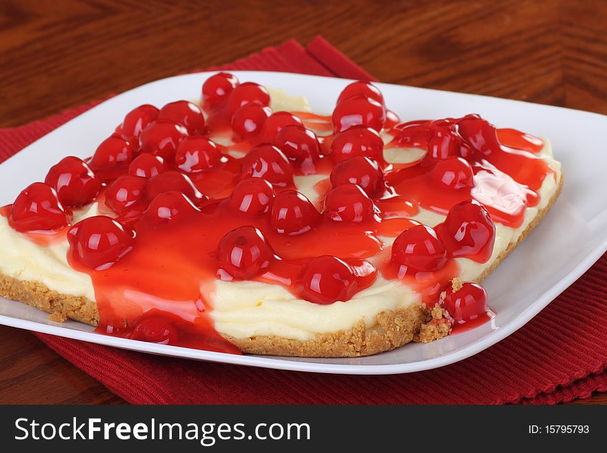 Cheesecake topped with juicy cherries on a plate. Cheesecake topped with juicy cherries on a plate