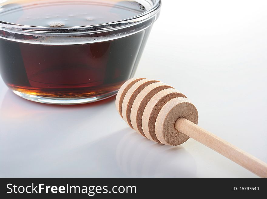 Honey in glasswares with wooden honey dipper.