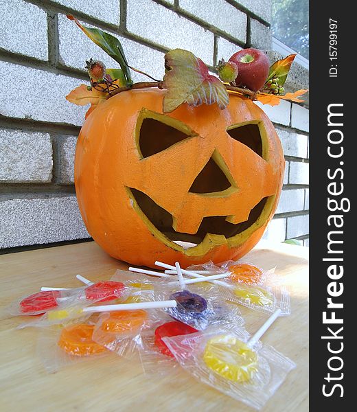 Plastic pumpkin with leafs ornament and candies. Plastic pumpkin with leafs ornament and candies