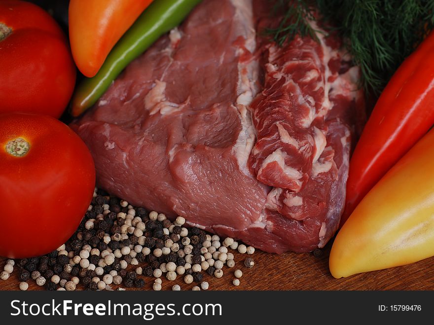 Raw beef with multicolored pepper, tomato and paprika. Selective focus. Raw beef with multicolored pepper, tomato and paprika. Selective focus