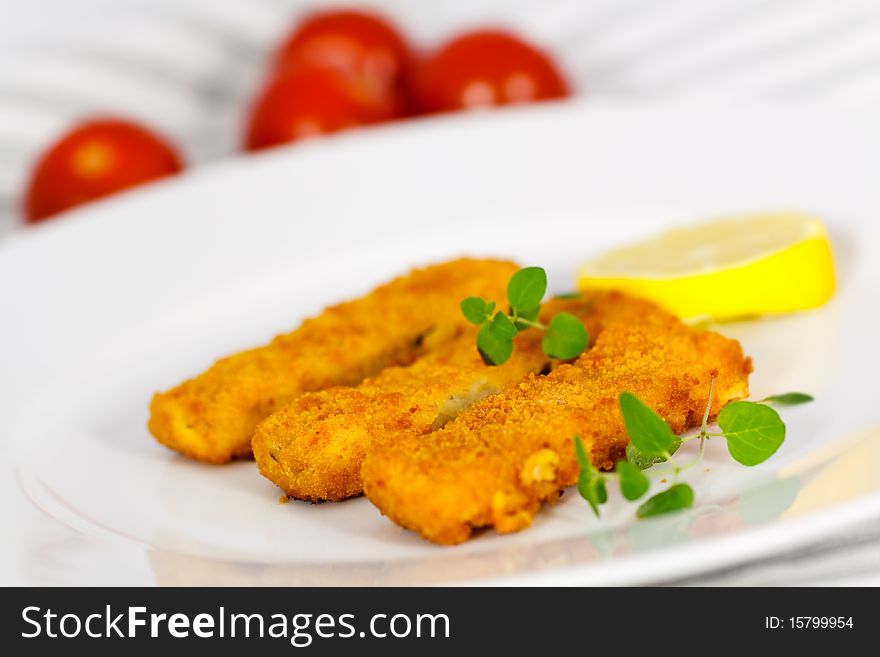 Close up,three fish fingers and slice of lemon.