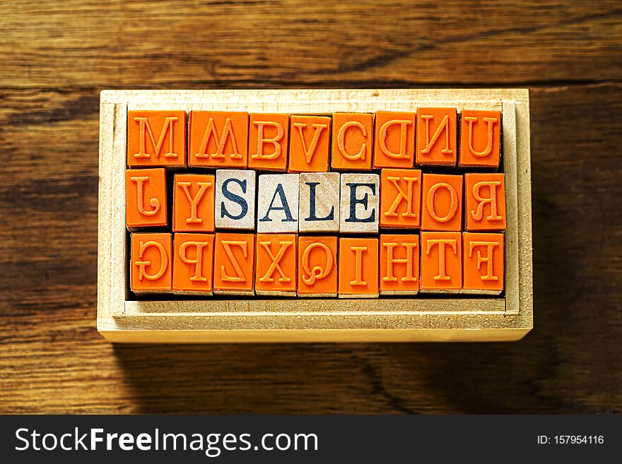 SALE -  abstract in wood type stamps against wooden background and copy space