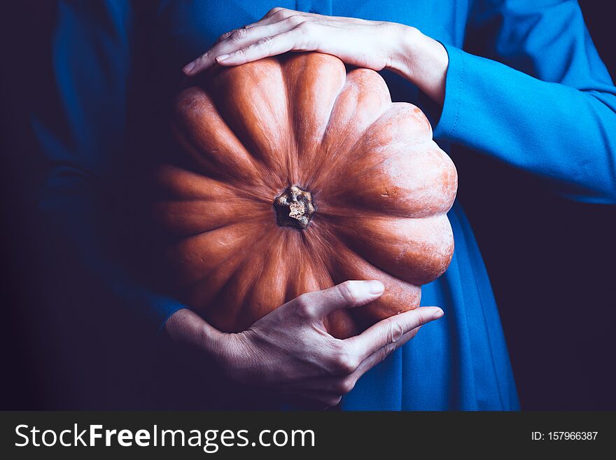 Girl holding beautiful aesthetic pumpkin on a black background. Halloween. Girl holding beautiful aesthetic pumpkin on a black background. Halloween