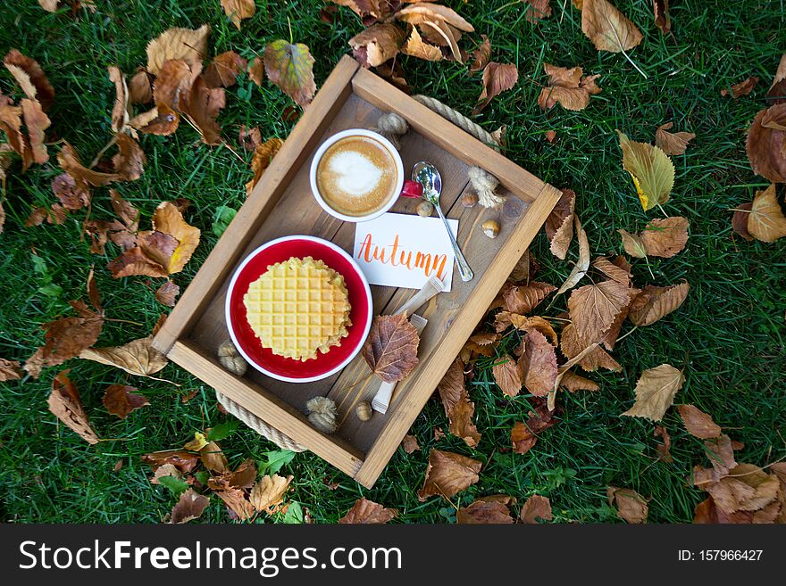 Breakfast - waffles and cup of coffee on a wooden tray. inscription autumn