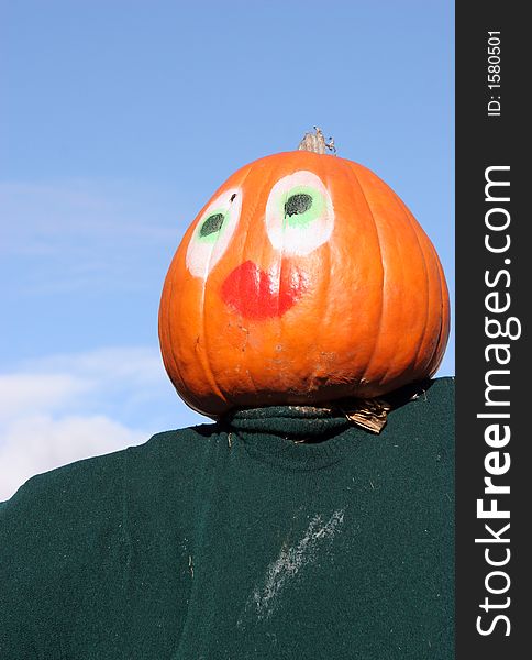 Pumpkin person against a blue sky. This is part of a display in Canada for Halloween.